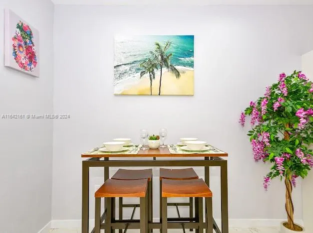 a view of a patio with a table and chairs and wooden fence