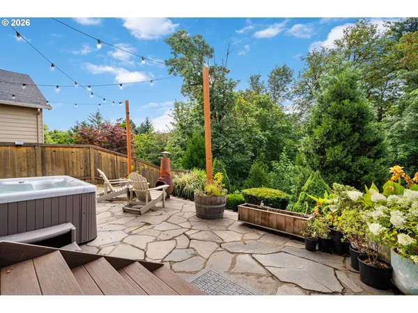 a backyard of a house with table and chairs potted plants