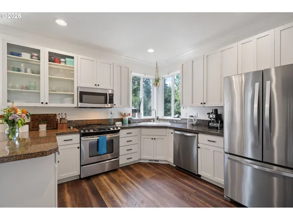 a kitchen with stainless steel appliances granite countertop a refrigerator a stove top oven a sink and dishwasher