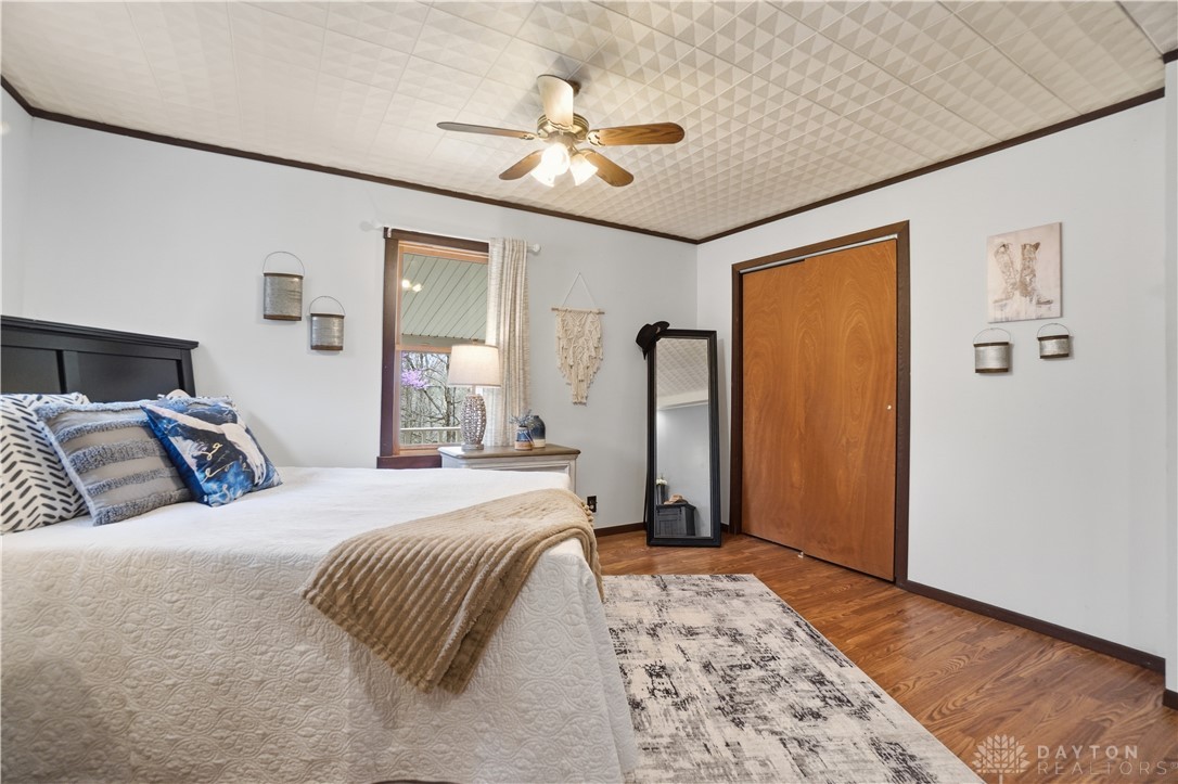 7553 Coffin Station Road Springfield, OH 45502 - Photo 54 of 95 This inviting bedroom features hardwood flooring and a functional ceiling fan for comfort.
