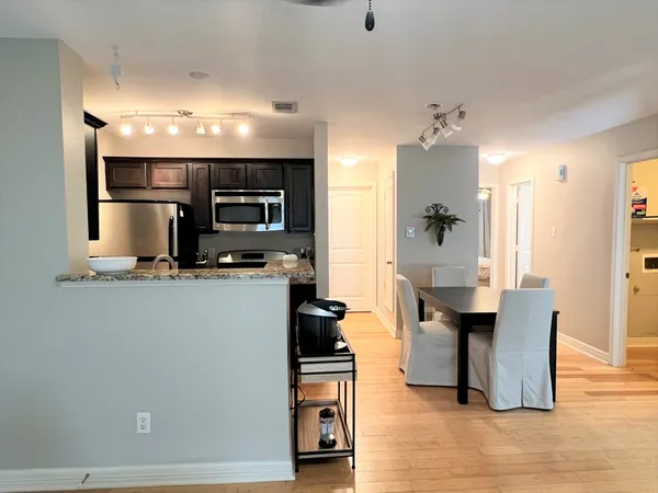 a kitchen with stainless steel appliances kitchen island granite countertop a refrigerator and a stove top oven