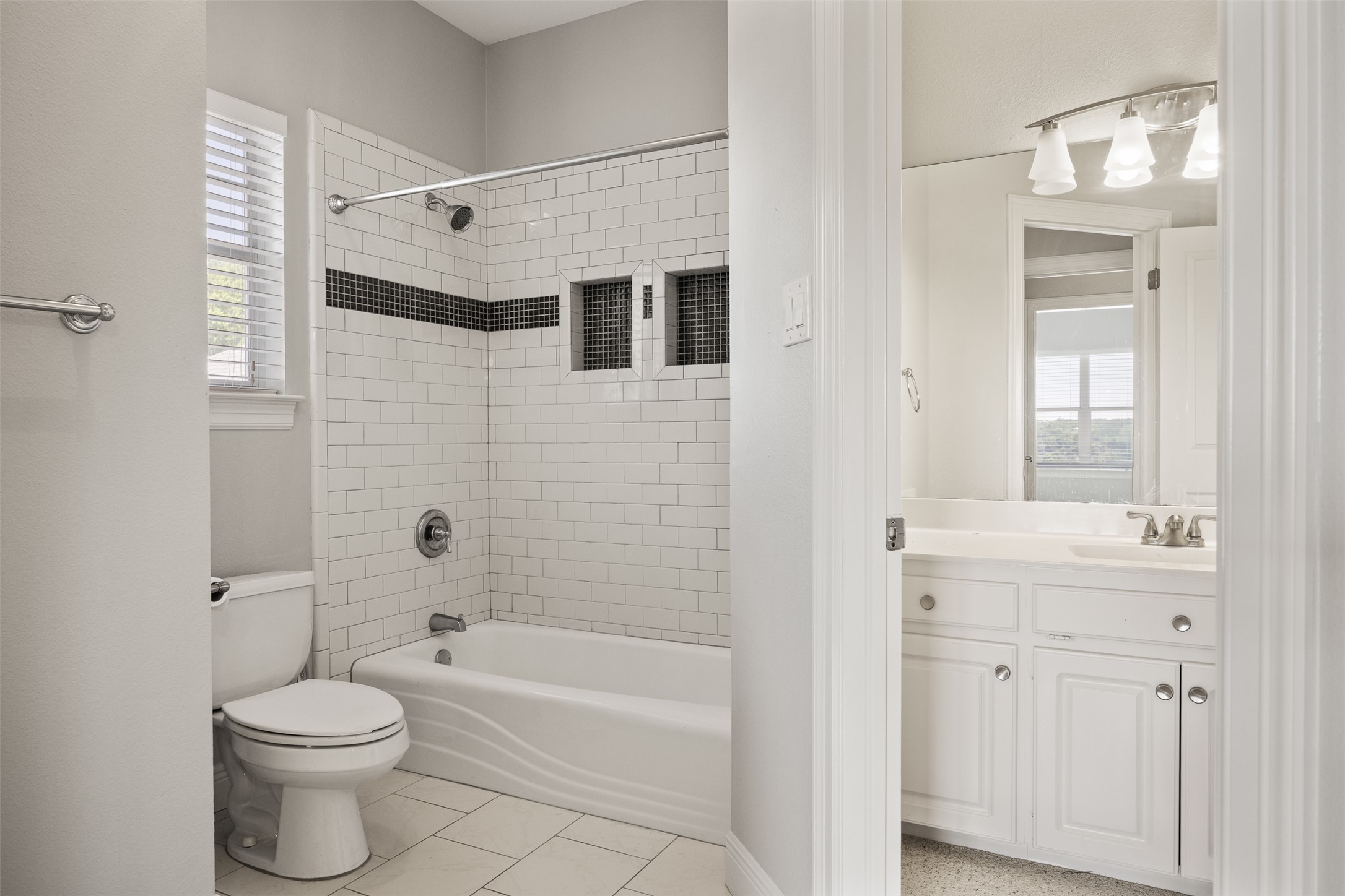 9300 Simmons Road Austin, TX 78759 - Photo 13 of 17 White subway tile and clean lines define this bright, functional bathroom.