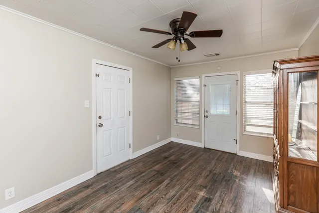 a view of a livingroom with wooden floor and a ceiling fan