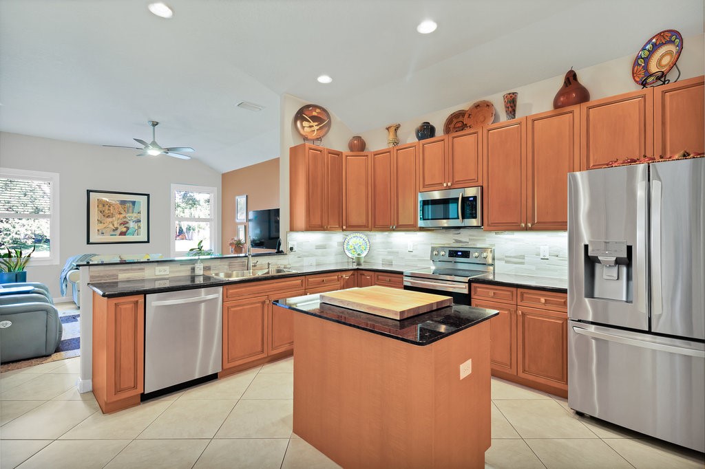 3812 Kitty Hawk Lane Southwest Vero Beach, FL 32968 - Photo 6 of 36 a kitchen with stainless steel appliances granite countertop a sink stove and refrigerator
