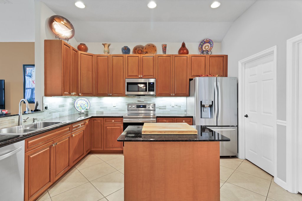 3812 Kitty Hawk Lane Southwest Vero Beach, FL 32968 - Photo 7 of 36 a kitchen with stainless steel appliances granite countertop a refrigerator sink and cabinets