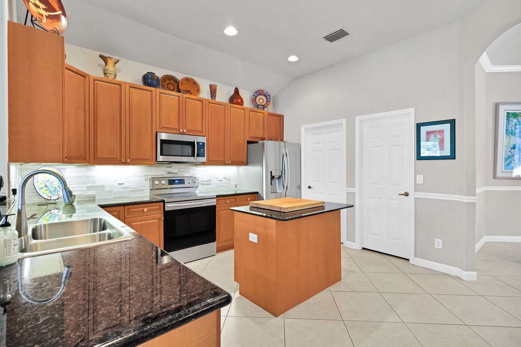 3812 Kitty Hawk Lane Southwest Vero Beach, FL 32968 - Photo 8 of 36 a kitchen with stainless steel appliances granite countertop a sink stove and refrigerator