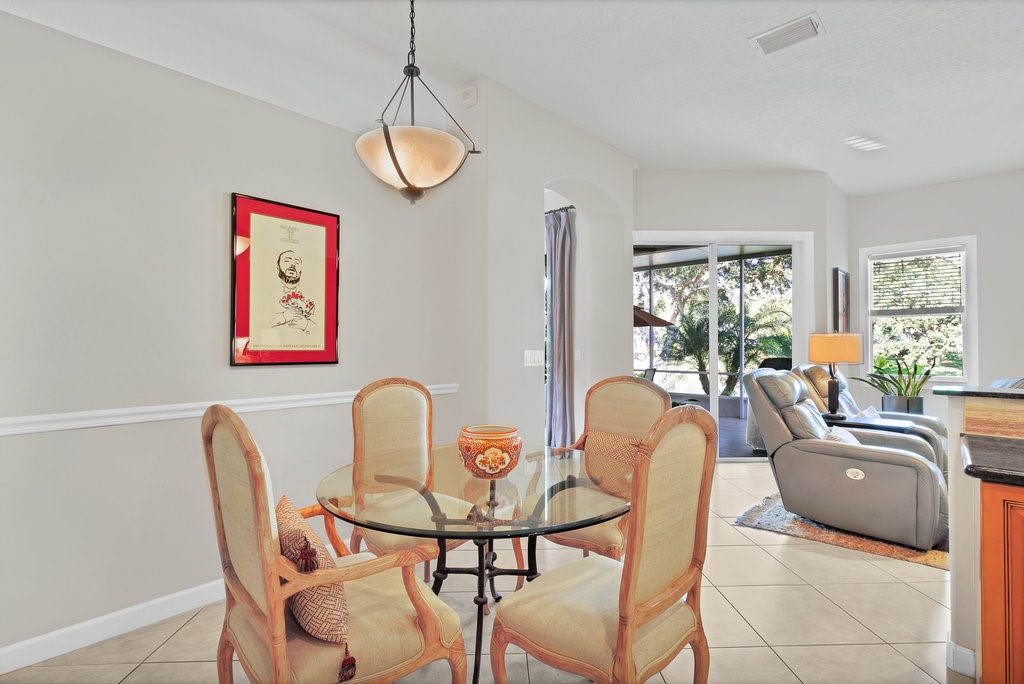 3812 Kitty Hawk Lane Southwest Vero Beach, FL 32968 - Photo 9 of 36 a dining room with furniture a window and a chandelier