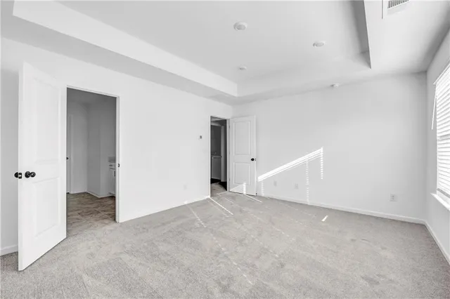 an empty room with an entryway and fan