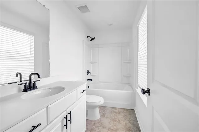 a bathroom with a tub a sink and a large mirror