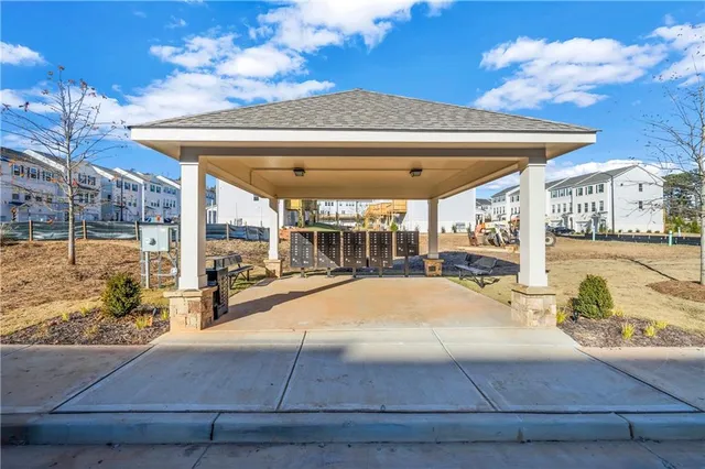 a patio with table and chairs and potted plants