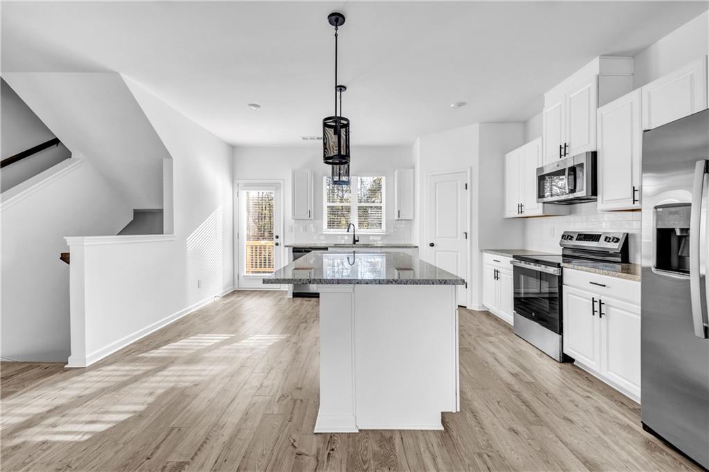 5772 Schelton Place Mableton, GA 30126 - Photo 7 of 24 a large kitchen with cabinets wooden floor and stainless steel appliances