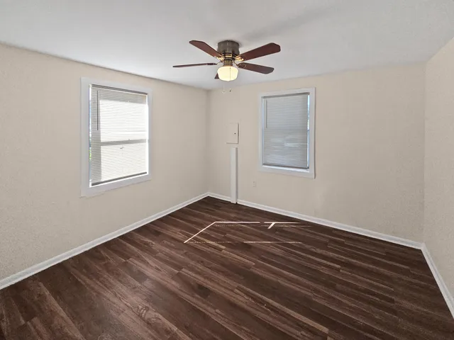 a view of a room with wooden floors and ceiling fan