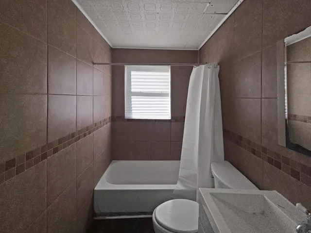 a bathroom with a toilet a sink and bathtub