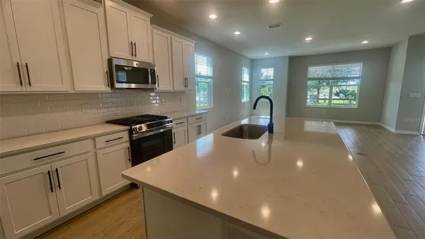 a kitchen with stainless steel appliances a microwave sink and cabinets