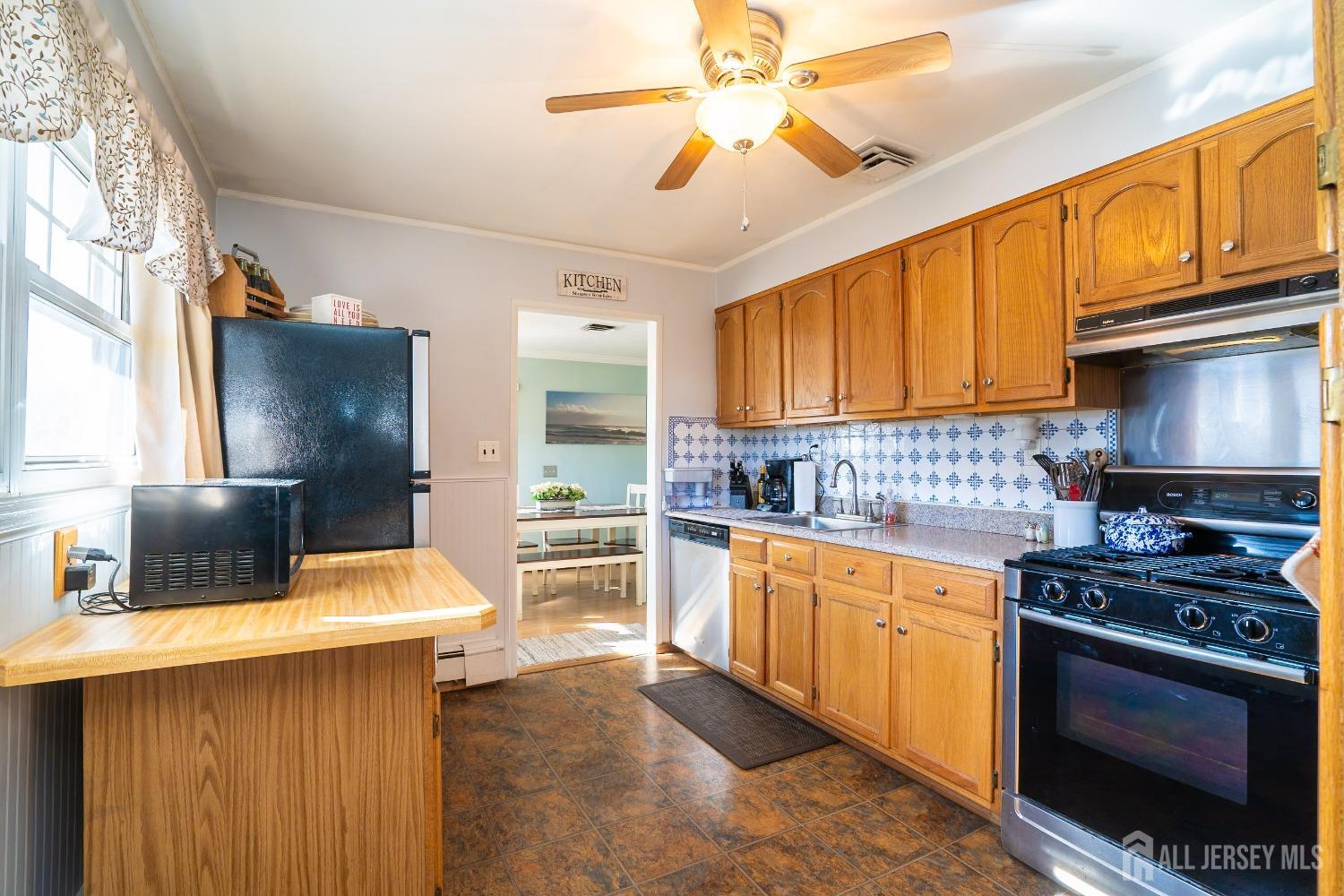 23 Winthrop Road Edison, NJ 08817 - Photo 5 of 29 a kitchen with stainless steel appliances a stove a sink cabinets and a window