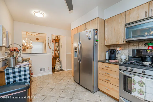 a kitchen with stainless steel appliances granite countertop a refrigerator stove and sink