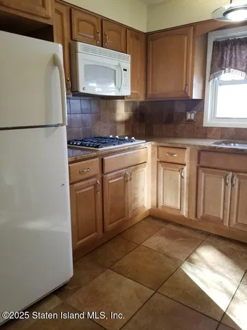 a kitchen with granite countertop a stove a sink and a microwave