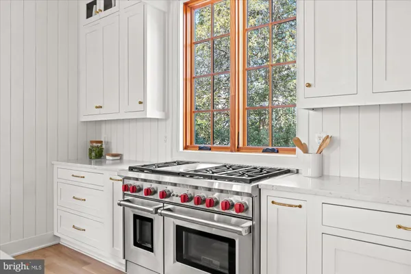 a kitchen with stainless steel appliances granite countertop a sink a stove a counter space and cabinets