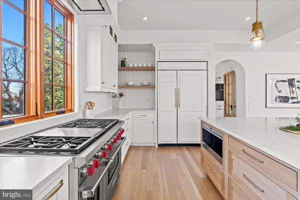 a kitchen with stainless steel appliances white cabinets and a window