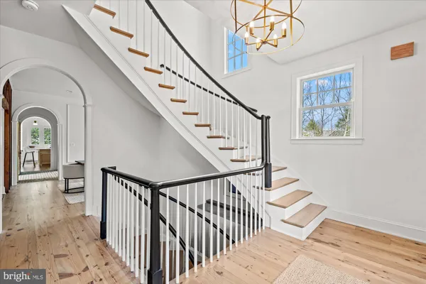 a view of staircase with lots of frames on wall and a chandelier