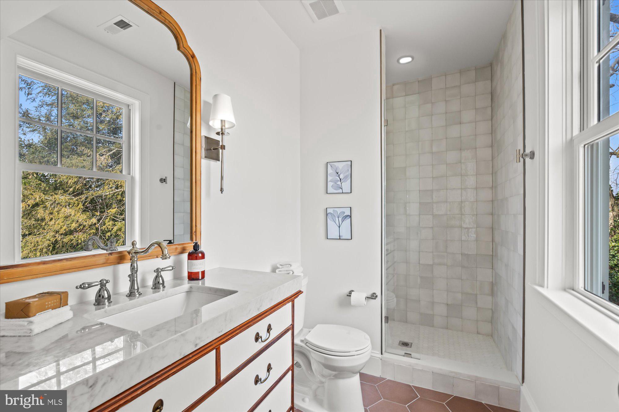 3612 North Glebe Road Arlington, VA 22207 - Photo 58 of 83 a bathroom with a granite countertop sink a toilet a mirror and shower