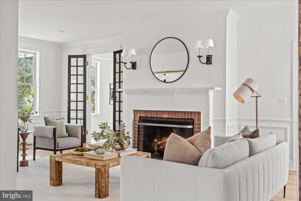 a living room with furniture a fireplace and a large window