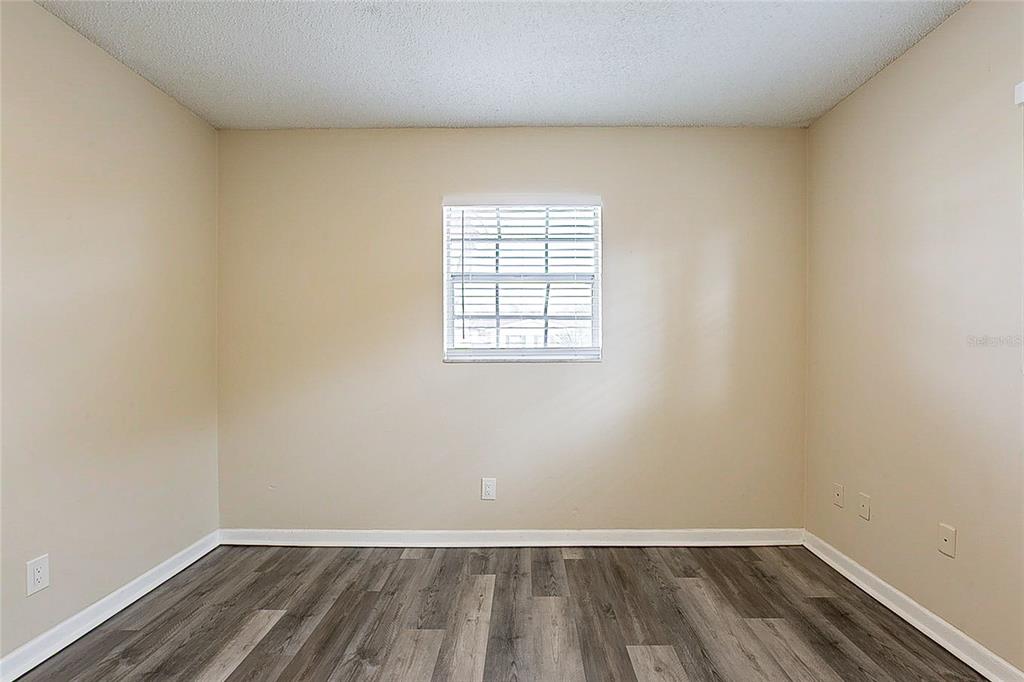 8528 Gold Ridge Circle Tampa, FL 33619 - Photo 13 of 31 an empty room with wooden floor and windows