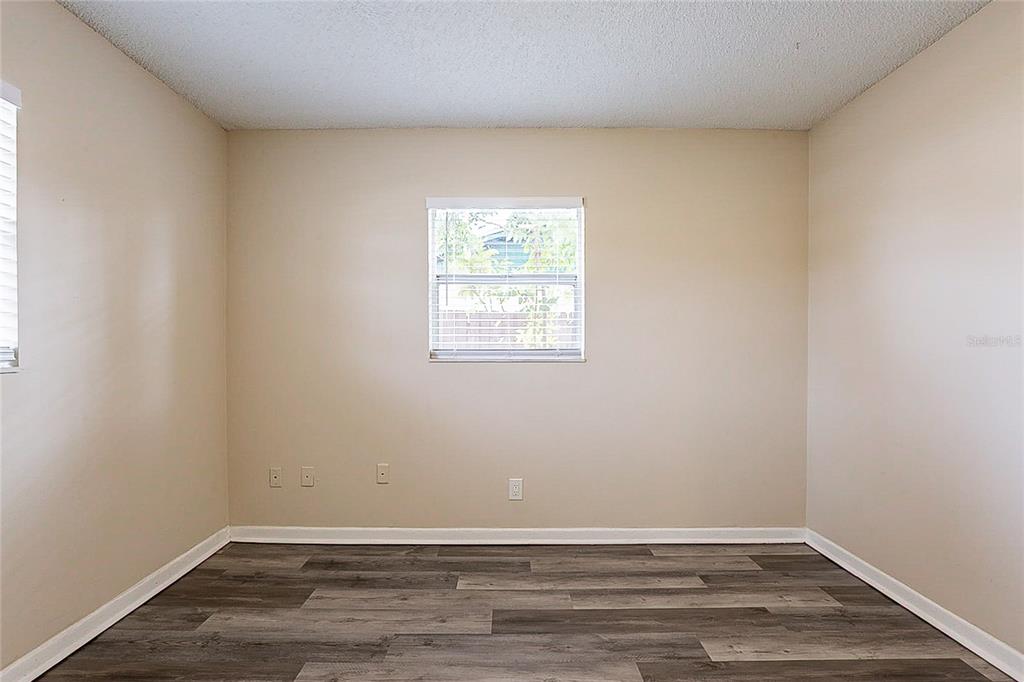 8528 Gold Ridge Circle Tampa, FL 33619 - Photo 16 of 31 an empty room with wooden floor and windows
