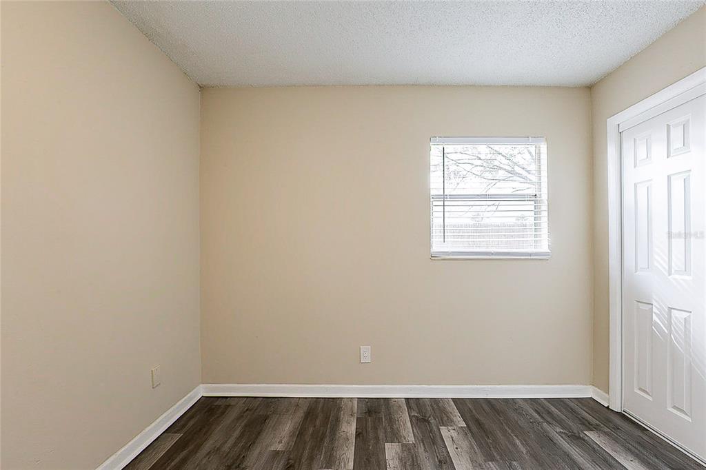 8528 Gold Ridge Circle Tampa, FL 33619 - Photo 17 of 31 an empty room with wooden floor and windows
