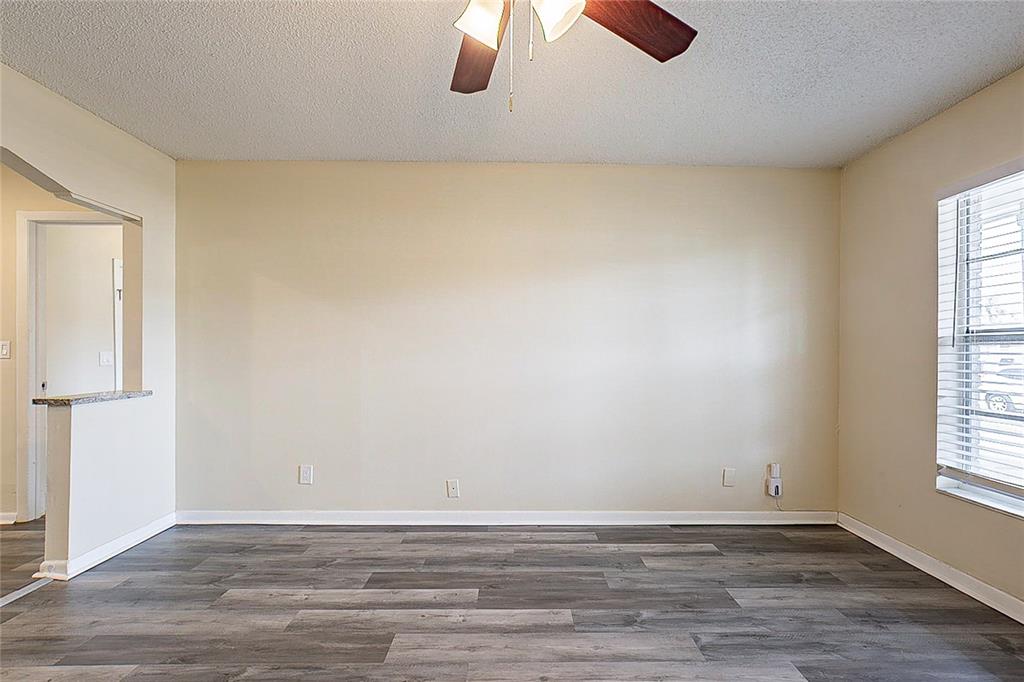 8528 Gold Ridge Circle Tampa, FL 33619 - Photo 5 of 31 an empty room with wooden floor chandelier fan and windows