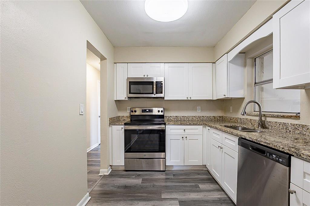 8528 Gold Ridge Circle Tampa, FL 33619 - Photo 6 of 31 a kitchen with stainless steel appliances granite countertop a sink stove microwave and refrigerator