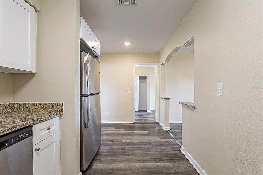 8528 Gold Ridge Circle Tampa, FL 33619 - Photo 7 of 31 a view of a hallway with wooden floor and staircase