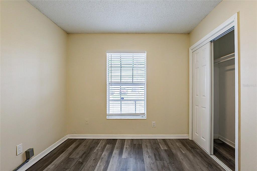 8528 Gold Ridge Circle Tampa, FL 33619 - Photo 9 of 31 an empty room with wooden floor and windows