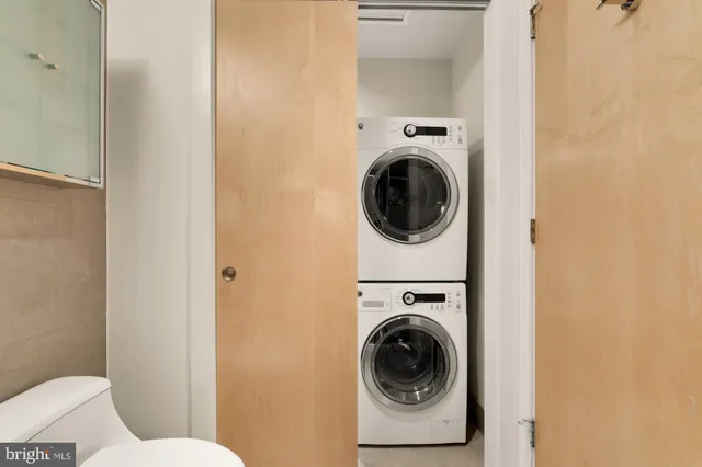 a utility room with dryer washer and a view of bathroom