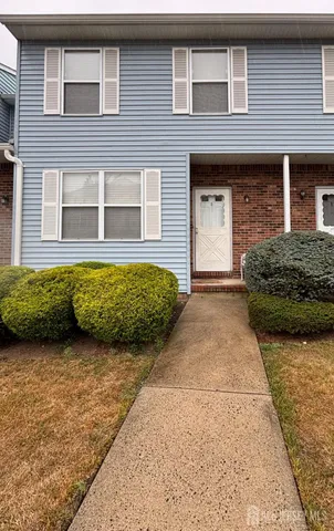 a view of a house with potted plants and a large tree