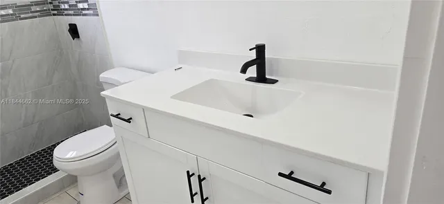 a bathroom with a sink a toilet and a shower