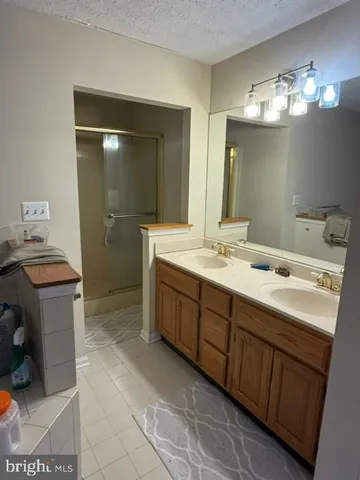 a spacious bathroom with a double vanity sink a mirror and a shower
