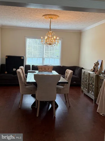 a dining room with furniture a chandelier and window