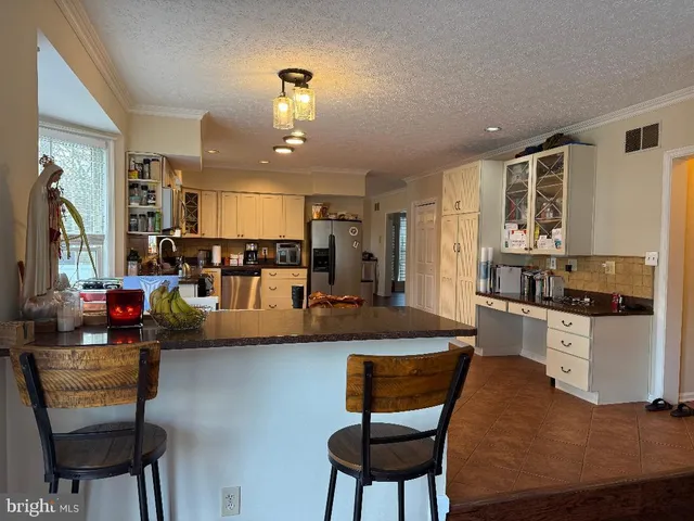 a kitchen with stainless steel appliances kitchen island granite countertop a stove a sink and a refrigerator