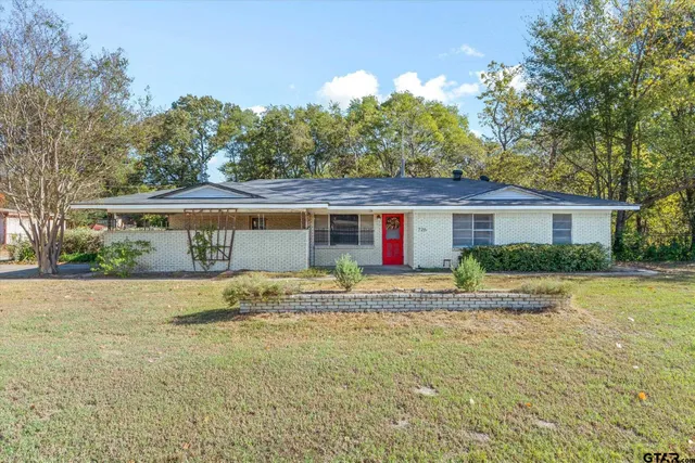 a view of a house with backyard and trees