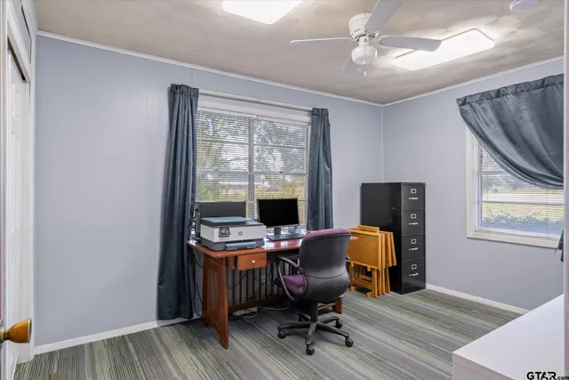 a view of a workspace with furniture and a window