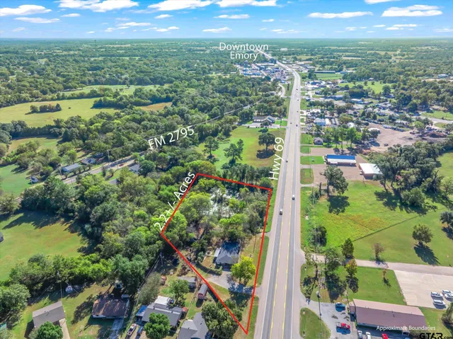 an aerial view of residential houses with outdoor space and trees