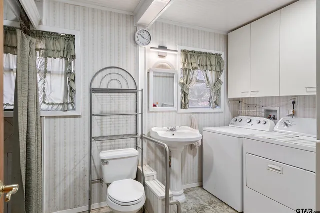a view of bathroom with a toilet sink and mirror