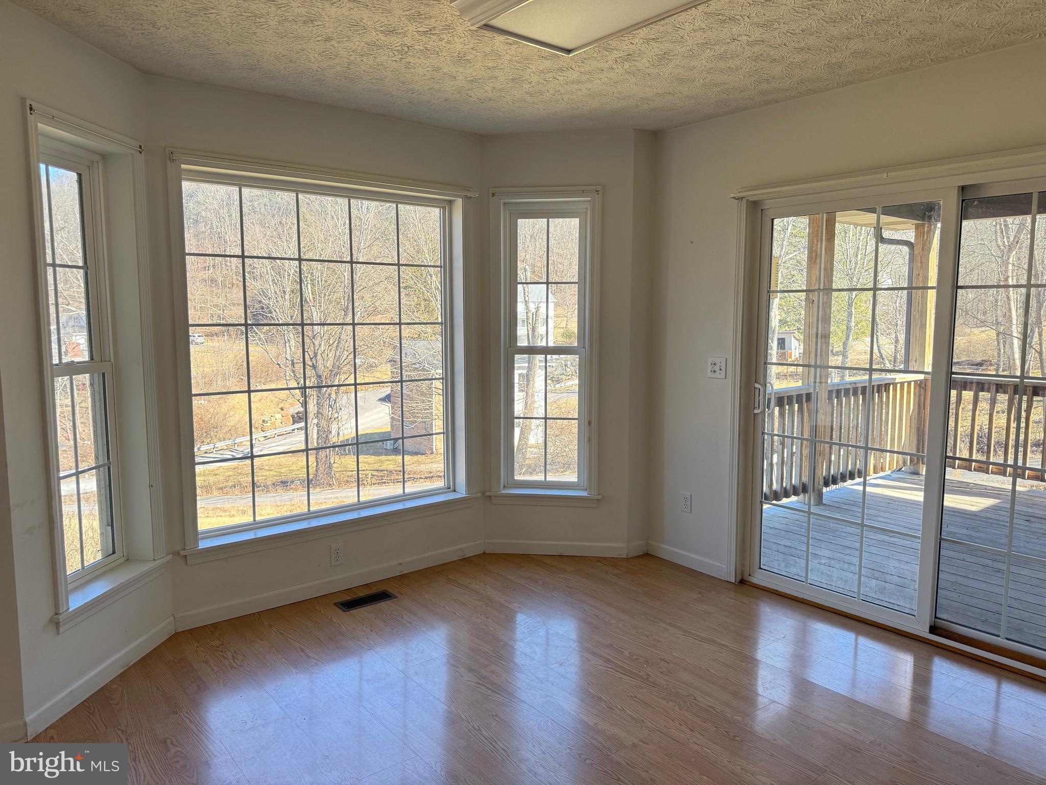 19322 Old Dans Rock Road Southwest Frostburg, MD 21532 - Photo 22 of 67 a view of an empty room with wooden floor and a window