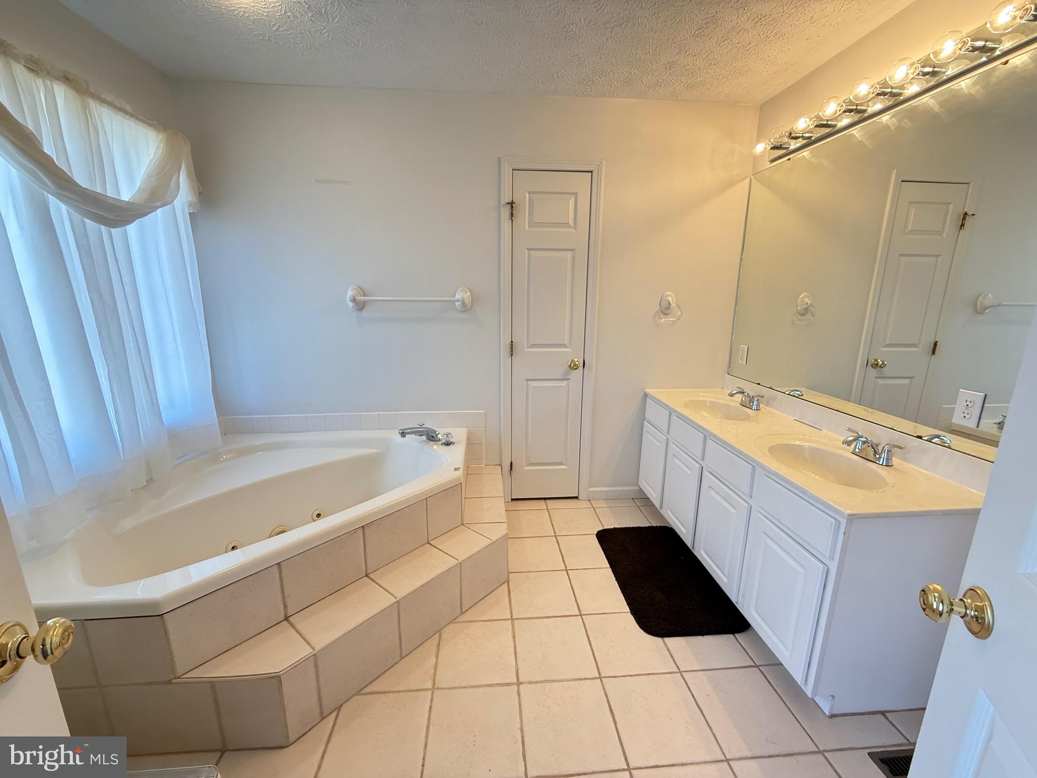 19322 Old Dans Rock Road Southwest Frostburg, MD 21532 - Photo 32 of 67 a bathroom with a double vanity sink a toilet a mirror and bathtub