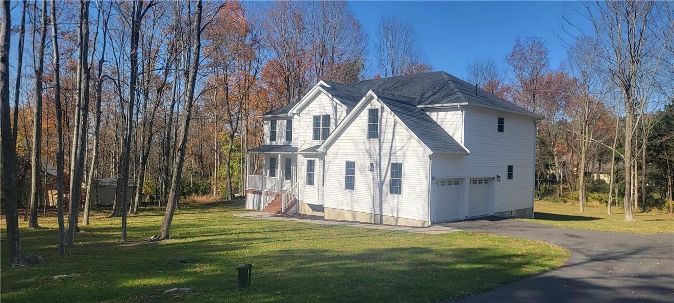 View of home's exterior with a yard and a garage