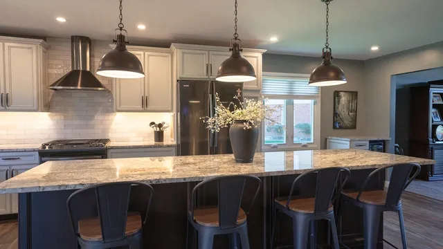 a kitchen with stainless steel appliances granite countertop a sink a stove and a wooden floors