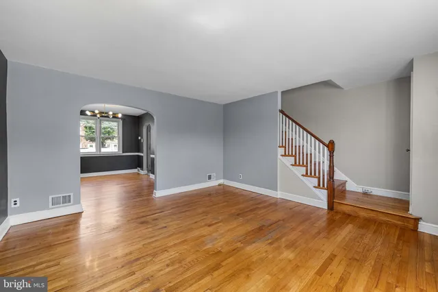 a view of an empty room with window and wooden floor