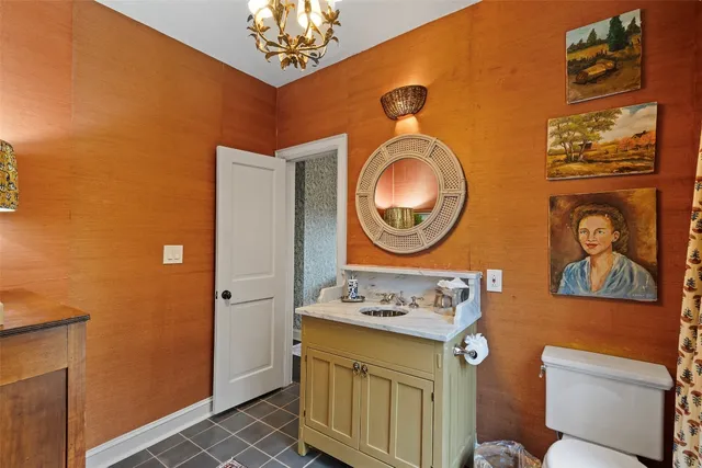 a bathroom with a toilet a sink and a mirror