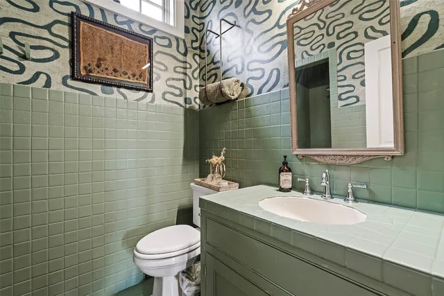 a bathroom with a granite countertop toilet sink and mirror